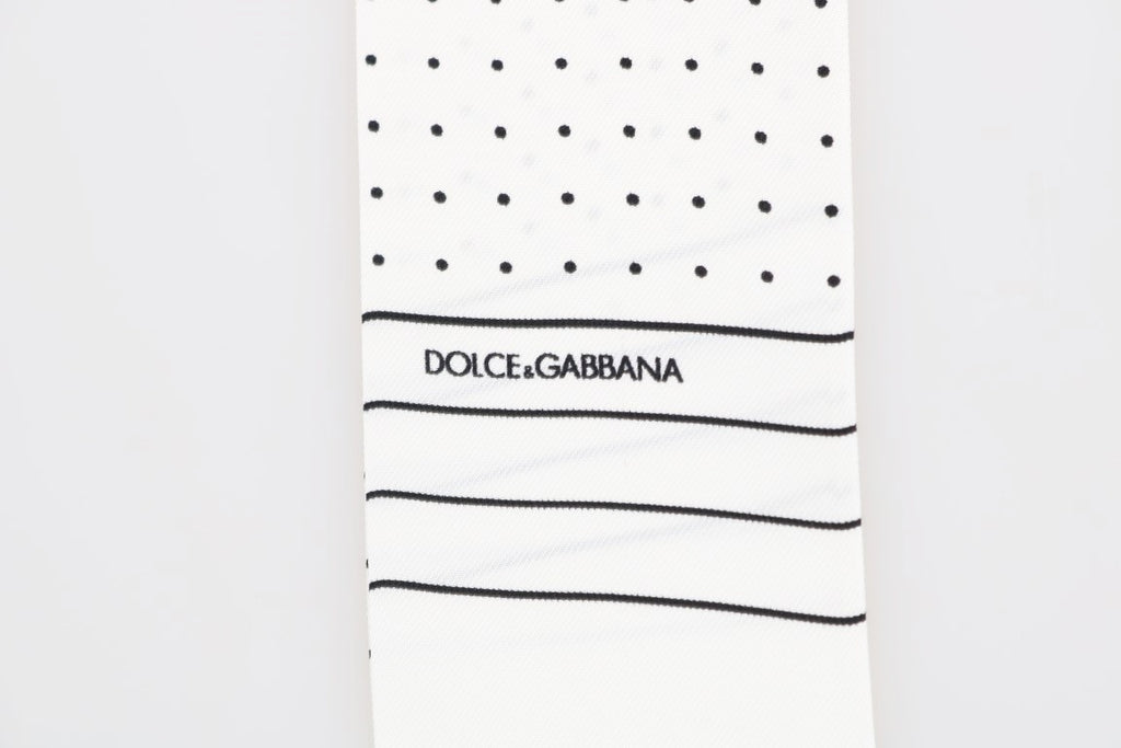 Foulard fin en soie blanc à pois noirs, Dolce & Gabbana, franges et logo, 140 × 25 cm.